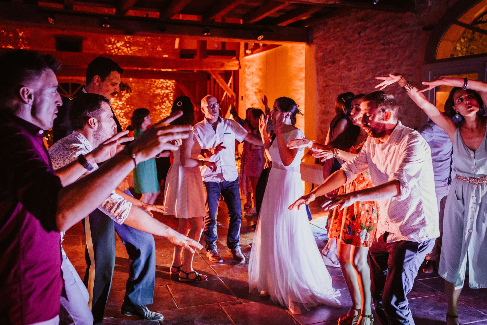 Animation sur la piste de danse sous mise en lumière ambrée — mariage au Domaine de Tilh à Loubieng, DJ Sud Évènements Sonorisation
